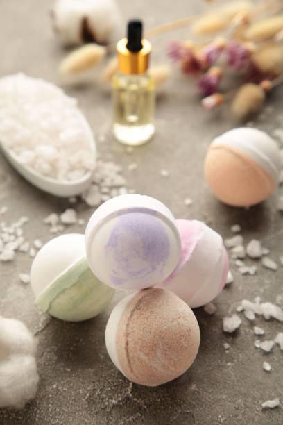 istock Composition with bath bombs, sea salt, dry flowers on grey background. Vertical photo 1365874700