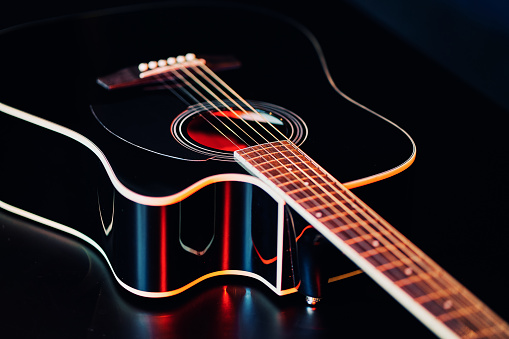 Classical guitar on a dark background. The scene is situated in a studio environment in front of a black background