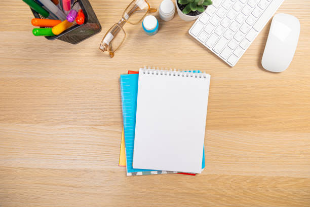 istock office stuff with pen and notepad keyboard on light wooden table top view. work at home 1365879921