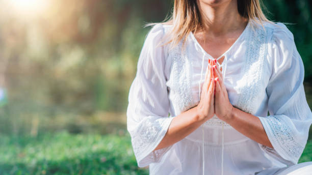 istock Meditation by the Water, Hands in Prayer Position. 1365880015
