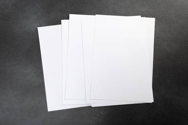 istock White business card sheet of paper a4 stack on a dark table. Clean portrait A4. 1365880097