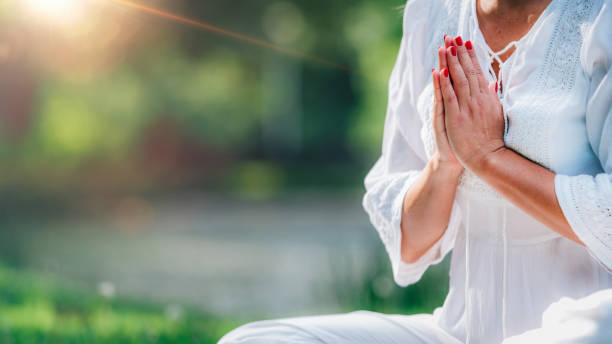 istock Meditation by the Water, Hands in Prayer Position. 1365881692