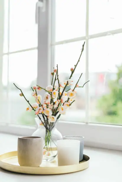 Photo of Vase with flowers and candles on the windowsill. Women's Day. Mother's Day. a beautiful romantic day. summer concept.