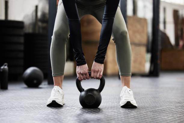 shot of a woman working out with a kettle bell - exercise imagens e fotografias de stock