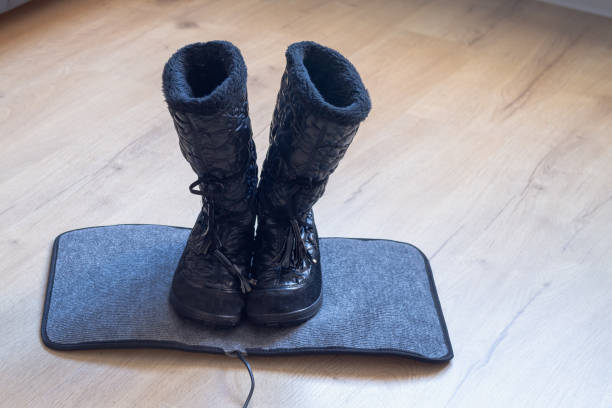 istock Winter boots dry on an electric mat for drying wet shoes 1365887004