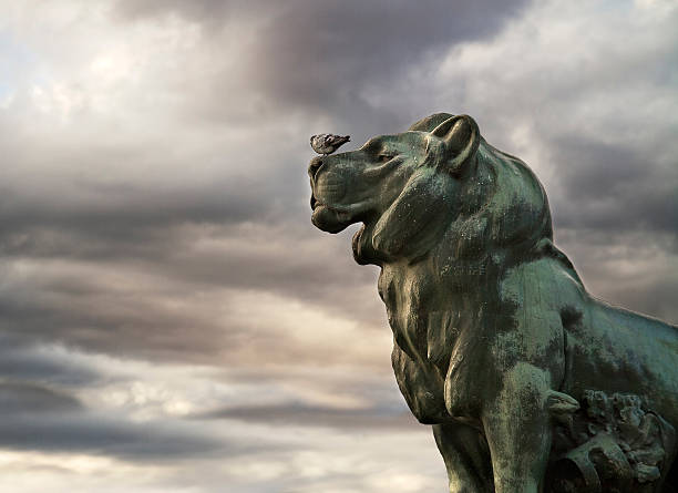 Statue of a lion with a dove in the Parque del Retiro (Madrid)