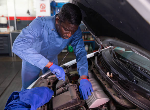 istock Professional american mechanic man in uniform repairing car engine 1365889289