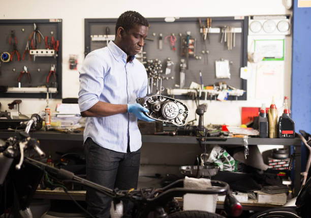 istock Mechanic installs a repaired engine on a motorcycle 1365889880