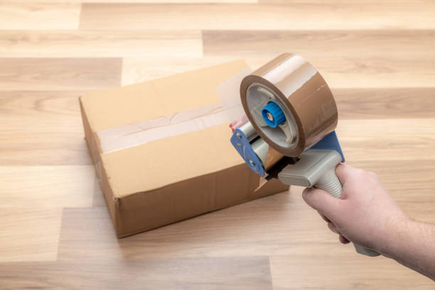 istock Holding a packing tape gun 1365890826