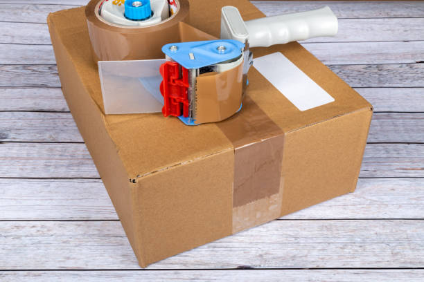 istock Cardboard box with packing tape gun 1365891541