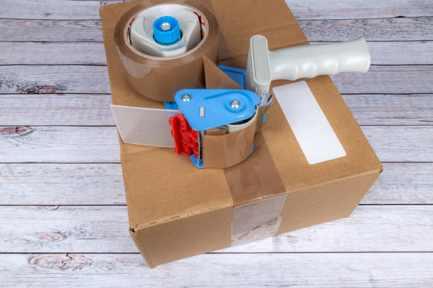istock Cardboard box with packing tape gun 1365891542