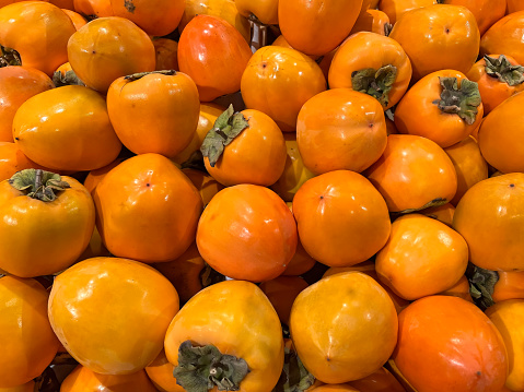 Fresh orange persimmon on store counter . High quality photo