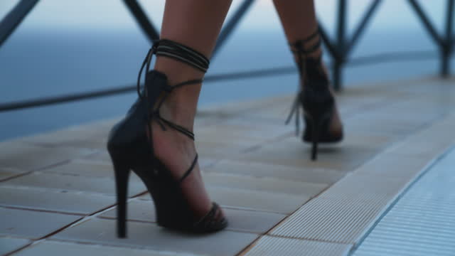Woman in seductive high heels arriving to a holiday villa with pool