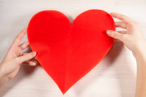 istock Paper red heart in hands 1365893651
