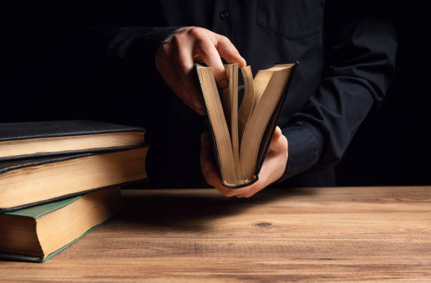 el hombre ilumina la oscuridad leyendo un libro - open book teaching table fotografías e imágenes de stock