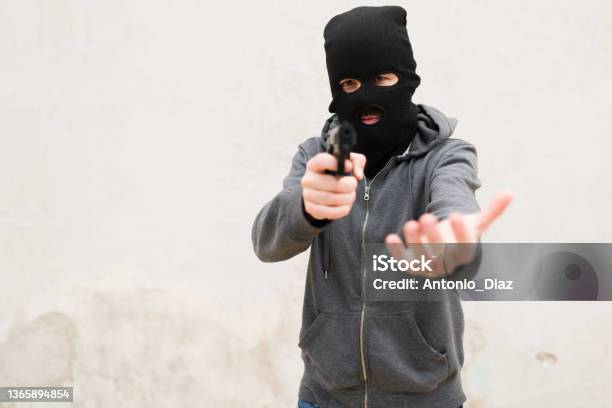 Robbery in store. Robber is aiming and threatening with gun in shop. Stock  Photo