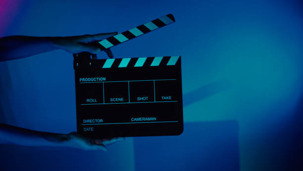 istock Hand holds empty film making clapperboard on color background in studio 1365896280