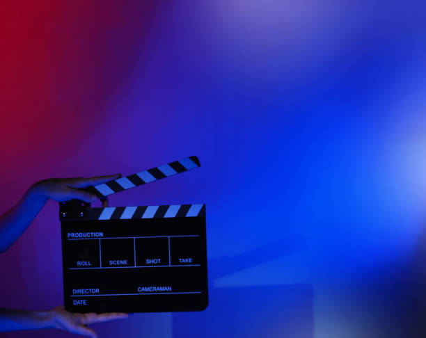 istock Hand holds empty film making clapperboard on color background in studio 1365896343