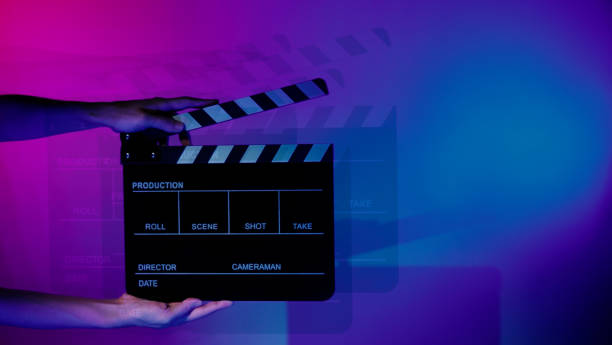 istock Hand holds empty film making clapperboard on color background in studio 1365896344