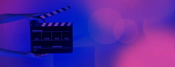 istock Hand holds empty film making clapperboard on color background in studio 1365896345