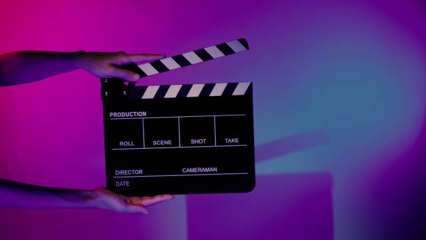 istock Hand holds empty film making clapperboard on color background in studio 1365896402