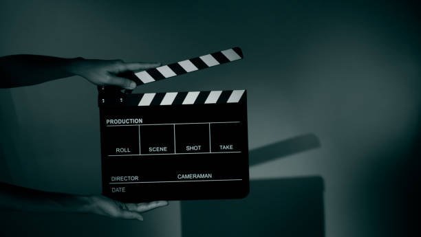 istock Hand holds empty film making clapperboard on color background in studio 1365896406
