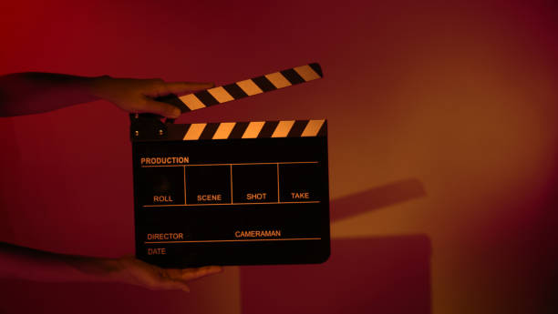 istock Hand holds empty film making clapperboard on color background in studio 1365896407