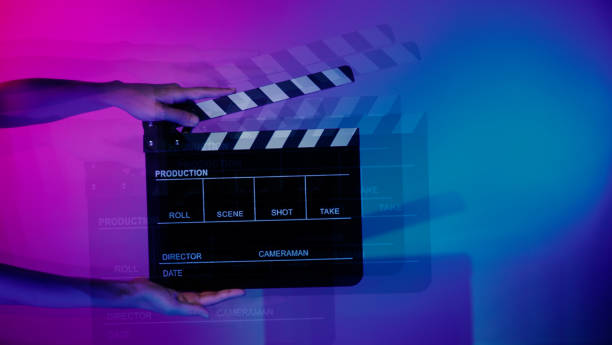 istock Hand holds empty film making clapperboard on color background in studio 1365896412