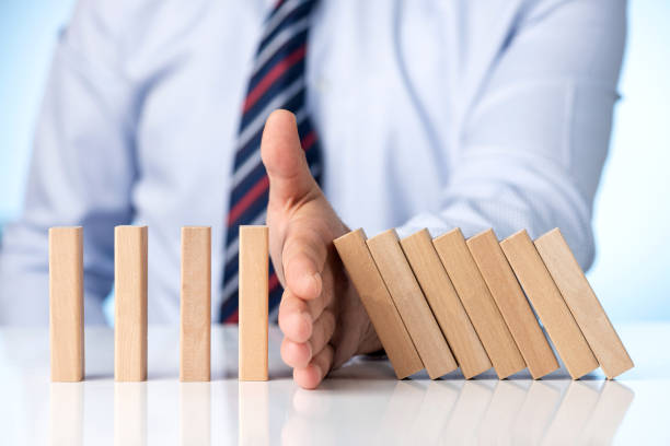 Risk Management and Insurance Concept. Businessman Stop Domino Effect. stock photo