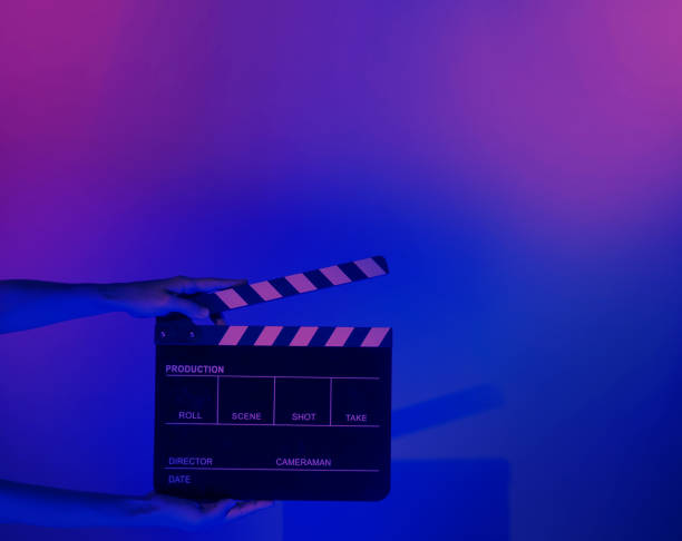 istock Hand holds empty film making clapperboard on color background in studio 1365896527