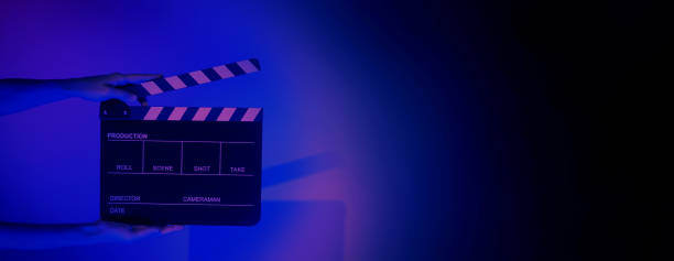 istock Hand holds empty film making clapperboard on color background in studio 1365896539