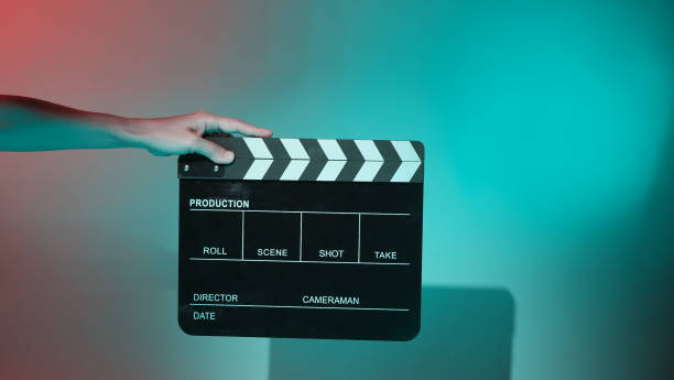 istock Hand holds empty film making clapperboard on color background in studio 1365896558