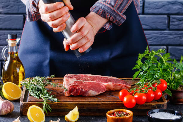 istock man cooking beefsteak on a kitchen, close-up 1365896575