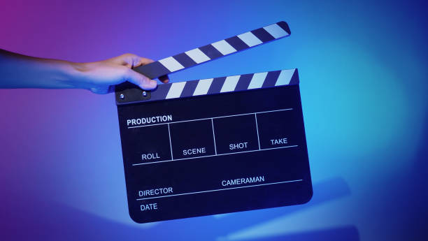 istock Hand holds empty film making clapperboard on color background in studio 1365896585
