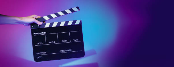 istock Hand holds empty film making clapperboard on color background in studio 1365896586
