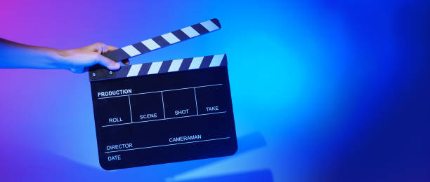 istock Hand holds empty film making clapperboard on color background in studio 1365896597