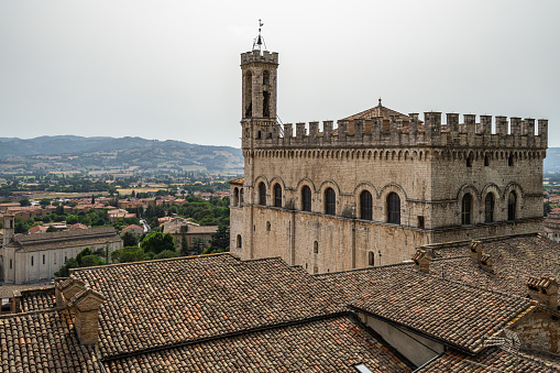 Gubbio, Italy, Aug. 2021 - Panoramic view on Gubbio historic center with Palazzo dei Consoli on the right