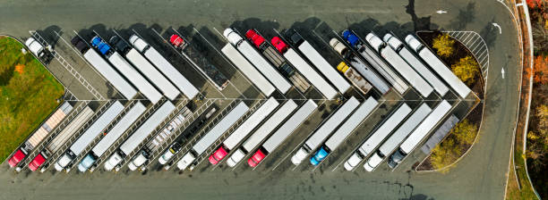 scatto panoramico top down drone di camion parcheggiati alla fermata del camion - trasporto merci via terra foto e immagini stock