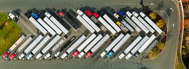 Panoramic Top Down Drone Shot of Trucks Parked at Truck Stop Stitched panoramic drone shot looking straight down on a line of diagonally parked trucks at a truck stop in Stamford, Connecticut on a sunny day in Fall. haulage stock pictures, royalty-free photos & images