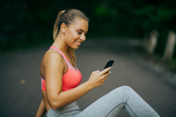 istock Young Sporty Woman using phone 1365899198
