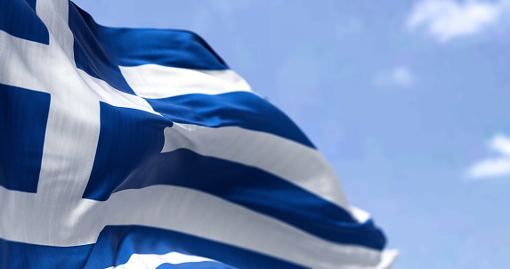 Detail of the national flag of Greece waving in the wind on a clear day. Democracy and politics. European country. Patriotism. Selective focus.