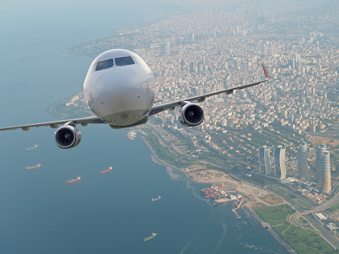 a white business plane takes off against the background of a blue sunny sky