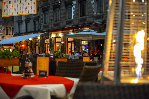 The flame from a patio heater warms a small outdoor, sidewalk cafe late at night in Split Croatia