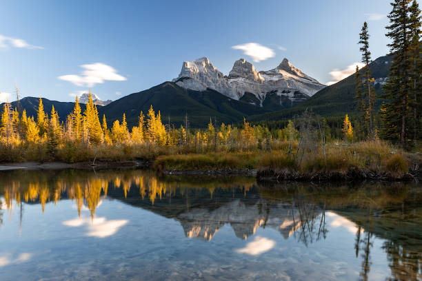 sunset view in canadian rockies with three sisters peaks reflecting in water, canmore, alberta, canada. - kananaskis country imagens e fotografias de stock