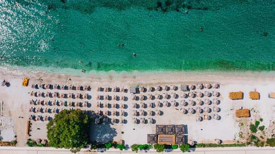 Drone photo of the summer beach resort with umbrellas at the Ionian Sea coast in Albania, the Balkans