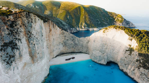 vista aérea panorámica de la playa escondida con naufragio junto al mar turquesa en la isla de zakynthos, grecia - wreck recreational boat nature mode of transport fotografías e imágenes de stock