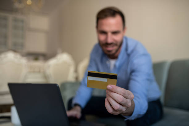 istock Selective focus. A young man using his credit card for online shopping. 1365906899