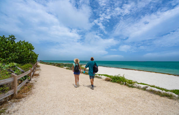 istock Couple walking along beautiful Florida beach. 1365907745