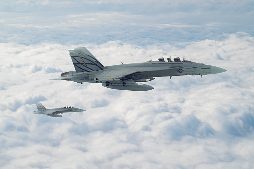 F-18 Jet fighters flying over clouds.