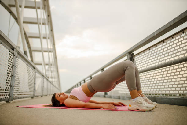 frau praktiziert yoga, glute bridge übung, dvi pada pithasana - bridge exercise stock-fotos und bilder